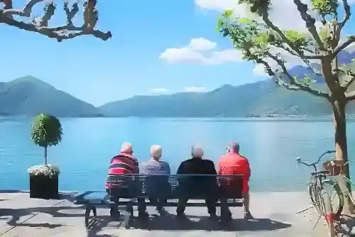 Séniors qui se détendent sur un banc au bord d'un lac.